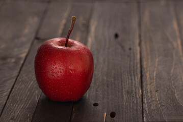 Fresh apple on dark wooden table with fruit basket