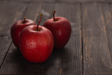 Fresh apples on dark wooden table with fruit basket