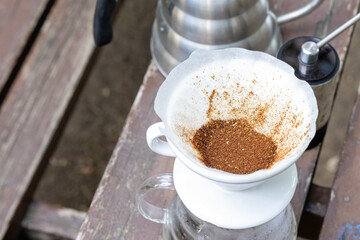 Brewing coffee on wooden table in the forest at camp