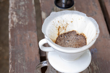 Brewing coffee on wooden table in the forest at camp