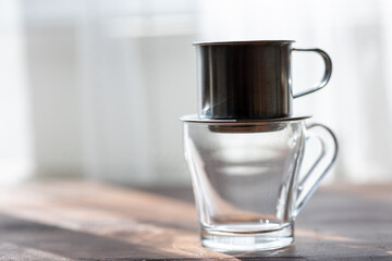 Brewing Elegance: Metal Dripper Pouring Rich Coffee into a Glass