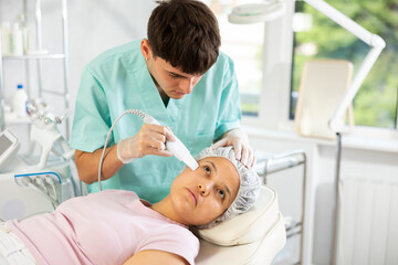 Fototapeta premium skilled dermatologist deftly wields skin scrubber attachment, ensuring rejuvenating treatment for patient's complexion.