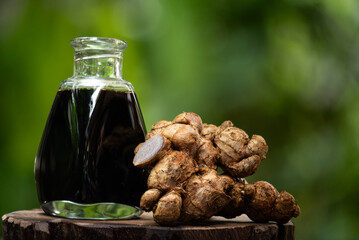 Black galingale or Kaempferia parviflora rhizomes and extract in glass bottles on natural...