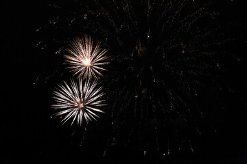 Two bright flashes of fireworks in the night sky