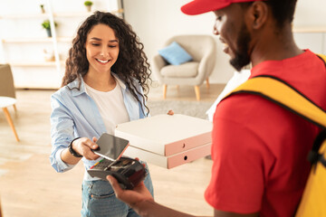 Delivery Concept. Portrait Of Smiling Millennial Female Customer Paying With Mobile Phone Standing...