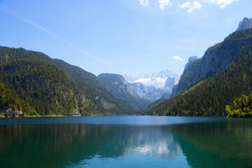 Naklejka premium Photography of Gosausee, Austria, showing alpine lake with turquoise water, surrounding Dachstein mountains, forests, and scenic natural landscape.