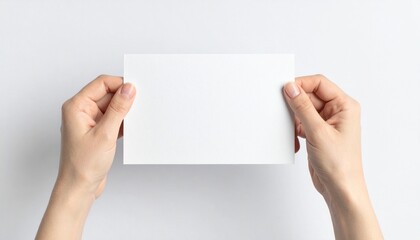 Fototapeta premium Two Hands Holding Blank White Paper Card on White Background