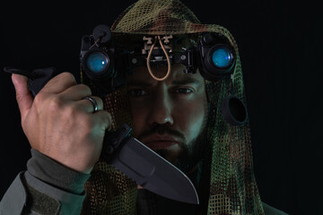 A special forces soldier with night vision goggles and a combat knife, ready for a high-stakes,...