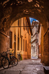 Lucca charming historical center in Tuscany. Medieval covered alley with bicycles