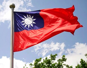 A national flag of taiwan, with a symbol and waving in the breeze against a partly cloudy sky.