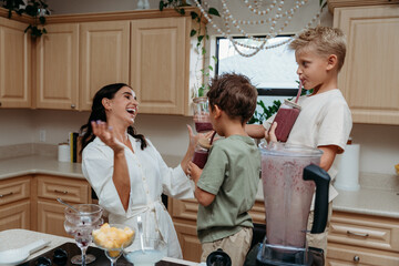 Boys and mom joyfully preparing smoothie 