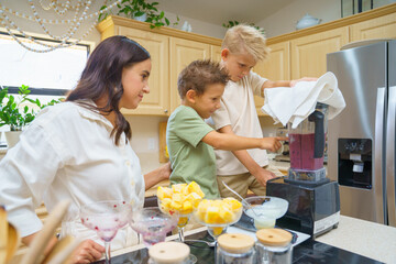 Boys and mom joyfully preparing smoothie 