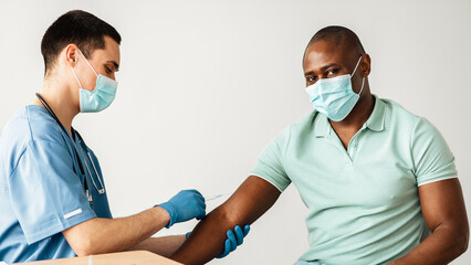 Medicine, vaccine, immunity and disease prevention. Millennial doctor in protective mask make...