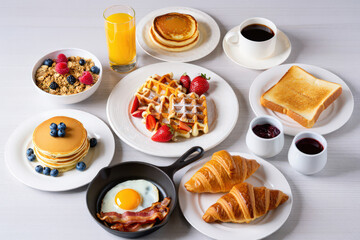 Lavish Breakfast Spread Featuring Pancakes, Waffles, Eggs, Bacon, Croissants, Toast, Cereal, Juice, and Coffee on a White Tabletop for a Delicious Morning Meal