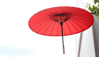 Red umbrella against a light gray wall
