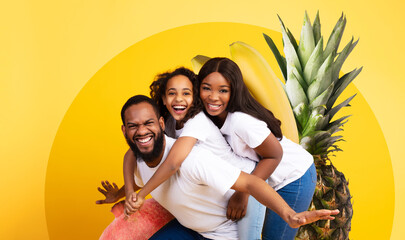 A vibrant collage showcases African American family posing playfully with fruits against a bright...