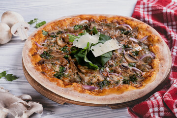 Freshly baked mushroom pizza on light background. Italian style mushroom pizza. Tasty vegetarian mushroom pizza. Delicious homemade pizza with mushrooms.