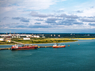Obraz premium Gas tankers over refinery Esso Oil Terminal from drone, Southampton, Hampshire, England, Europe