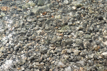 Pebbles and Rocks on a Beach with Clear Transparent Sea Water in Croatia. texture