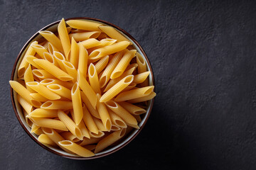 Penne Pasta in Bowl on Dark Background Top View Copy Space