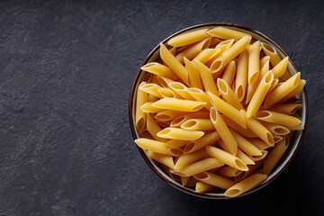 Penne Pasta in Bowl on Dark Background Top View Copy Space
