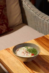 A Delicious Bowl of Creamy Soup Placed on a Beautiful Wooden Table for Enjoyment