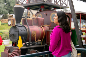 Tourist enjoying view of vintage steam locomotive in amusement park
