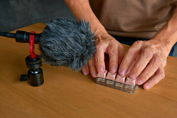 ASMR artist recording the satisfying sound of a mechanical keyboard with a professional microphone.