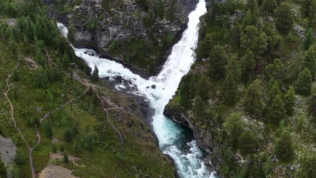 Top-down shot of a forked waterfall cascading through rocky cliffs in Norway Rondane