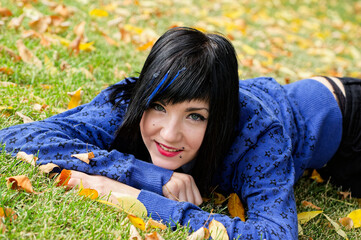 Woman Relaxing On Grass in Autumn Park Smiling, individuality femininity concepts