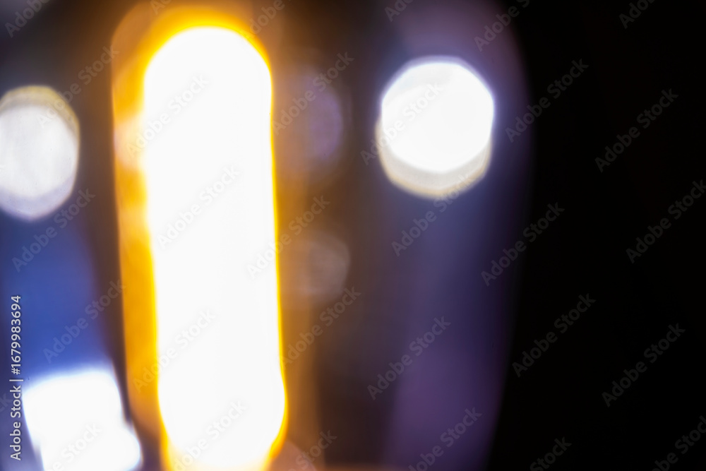 Poster abstract image showing blurred golden light with bokeh spheres against a dark background, creating a