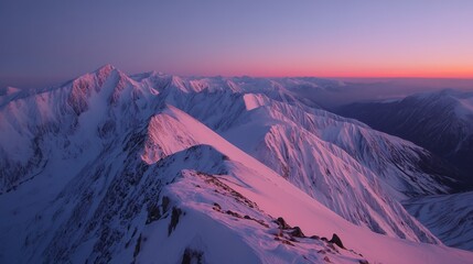 sunset snowy mountain peak with orange light and pink sky