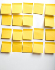 A grid of bright yellow sticky notes adheres to a plain white surface, creating a visual representation of organization and planning.