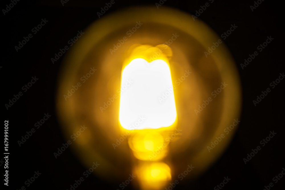 Poster abstract image showing blurred golden light with bokeh spheres against a dark background, creating a