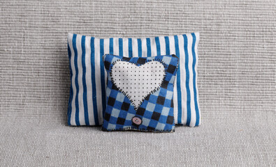 Striped and checked pillows with heart shape on sofa