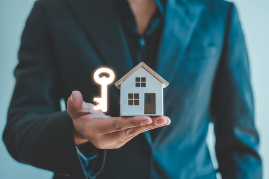 Find your dream home: real estate agent offering house and key for new homeowners and property investment - Powered by Adobe