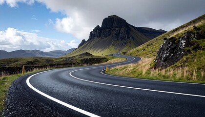 A winding road snakes through a landscape of lush green hills and towering mountains under a dramatic sky.