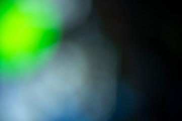 Abstract blurred background with a soft color gradient in shades of green, blue, and black. Texture or background in various designs