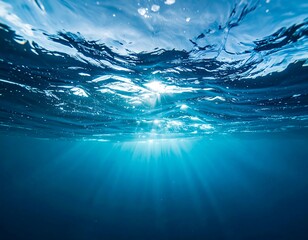 Underwater perspective of water surface, sunlight beams filtering through, creating a serene atmosphere.