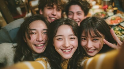 Fototapeta premium A joyful group of friends taking a selfie, showcasing smiles and camaraderie in a cozy setting filled with food.