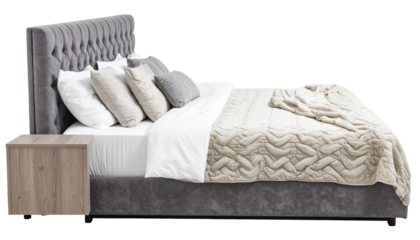 Luxurious bedroom setup featuring a button-tufted headboard, pillows, blanket, and a wooden bedside table