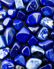 Close-up view of tumbled lapis lazuli stones, showcasing their vibrant blue hues and unique patterns.