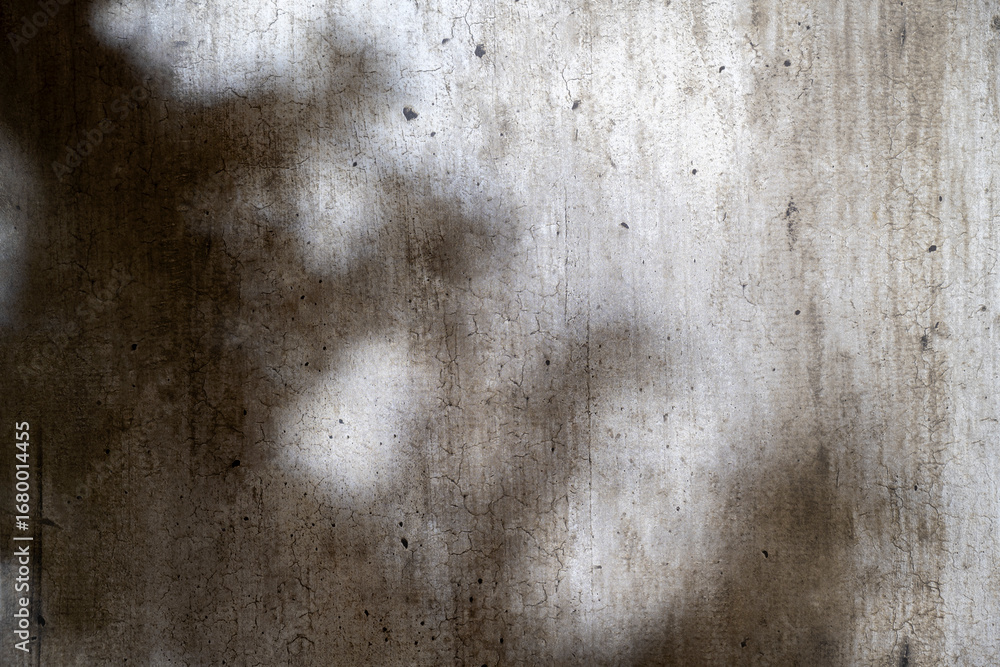 Poster abstract image of a grungy and aged cement surface. the texture features cracks and a shadow overlay