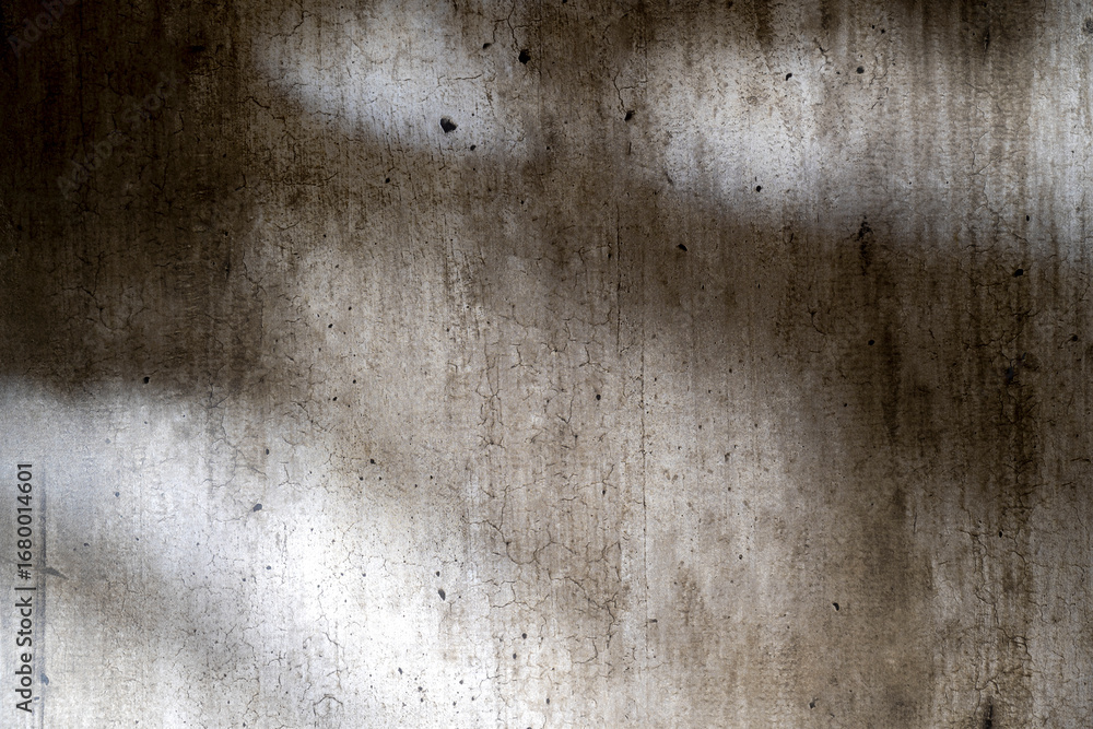 Poster abstract image of a grungy and aged cement surface. the texture features cracks and a shadow overlay
