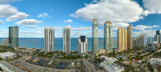Obraz premium Aerial view of Sunny Isles Beach city with luxurious highrise hotels and condos on Atlantic ocean shore. American tourism infrastructure in southern Florida