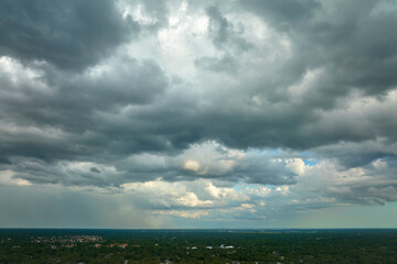 Dark stormy clouds forming on gloomy sky before heavy rainfall over suburban town area