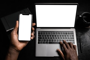Dark workspace, hands on laptop and phone