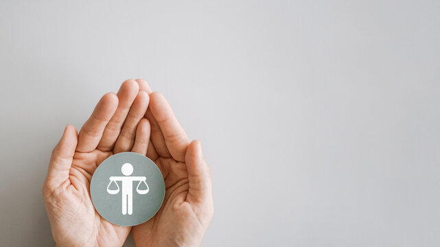 Hand holding Human justice scale badge , business ethics and corporate compliance concept
