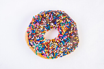 Chocolates donut close-up on a white background. Colorful Chocolate covered donuts with colorful sprinkles.