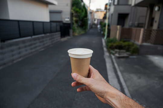 Coffee cup held up on quiet street